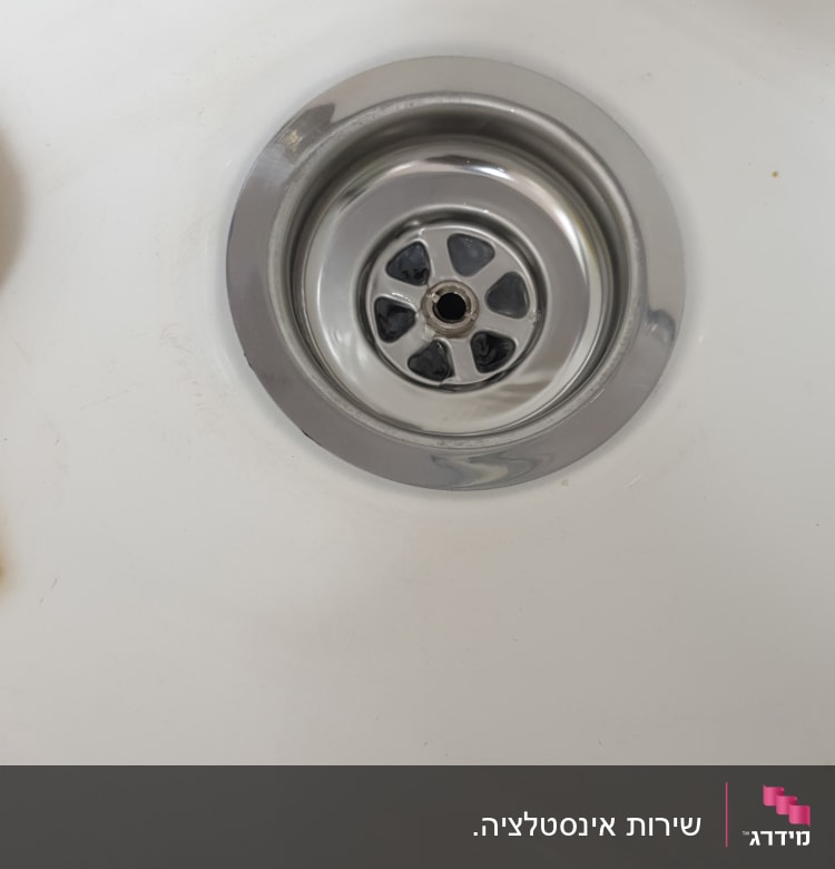 ניקוז מתכת בכיור לבן